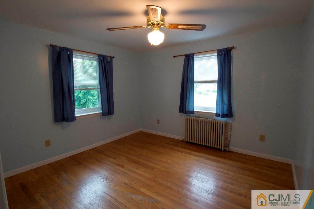 129 Middlesex Avenue Iselin, NJ 08830 - Photo 14 of 23 a view of an empty room with window and wooden floor