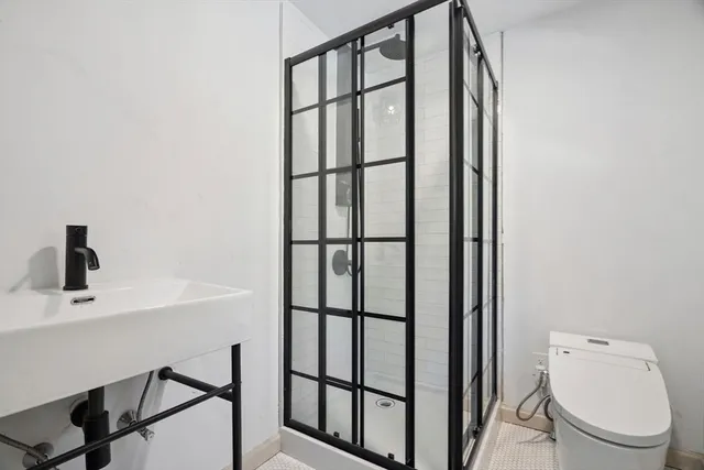 a bathroom with a toilet a sink and mirror