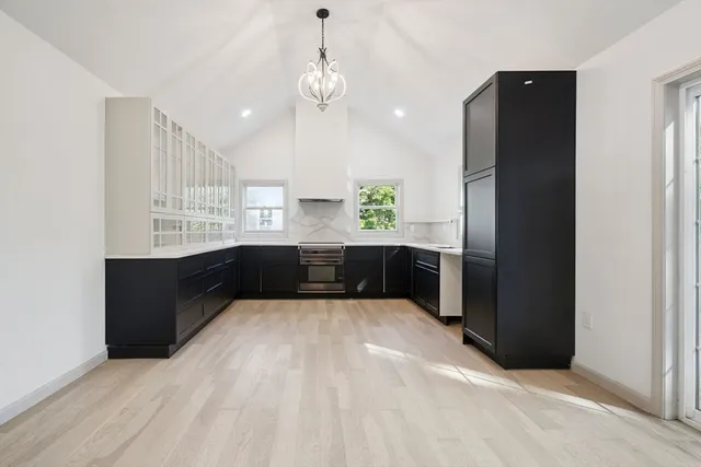 a large kitchen with a large counter top wooden cabinets and stainless steel appliances