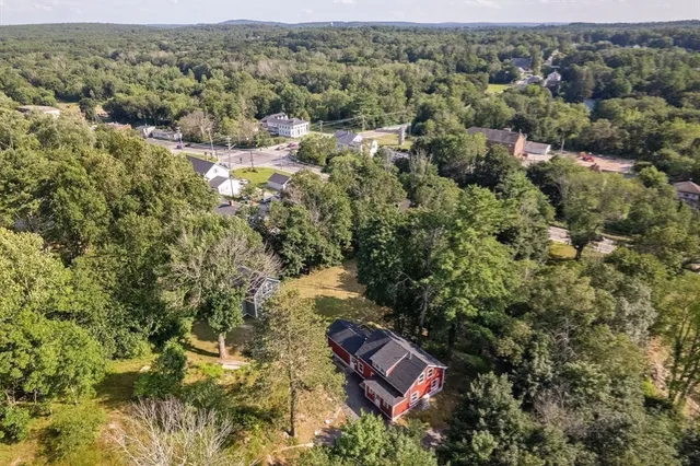 an aerial view of residential house with outdoor space and trees all around