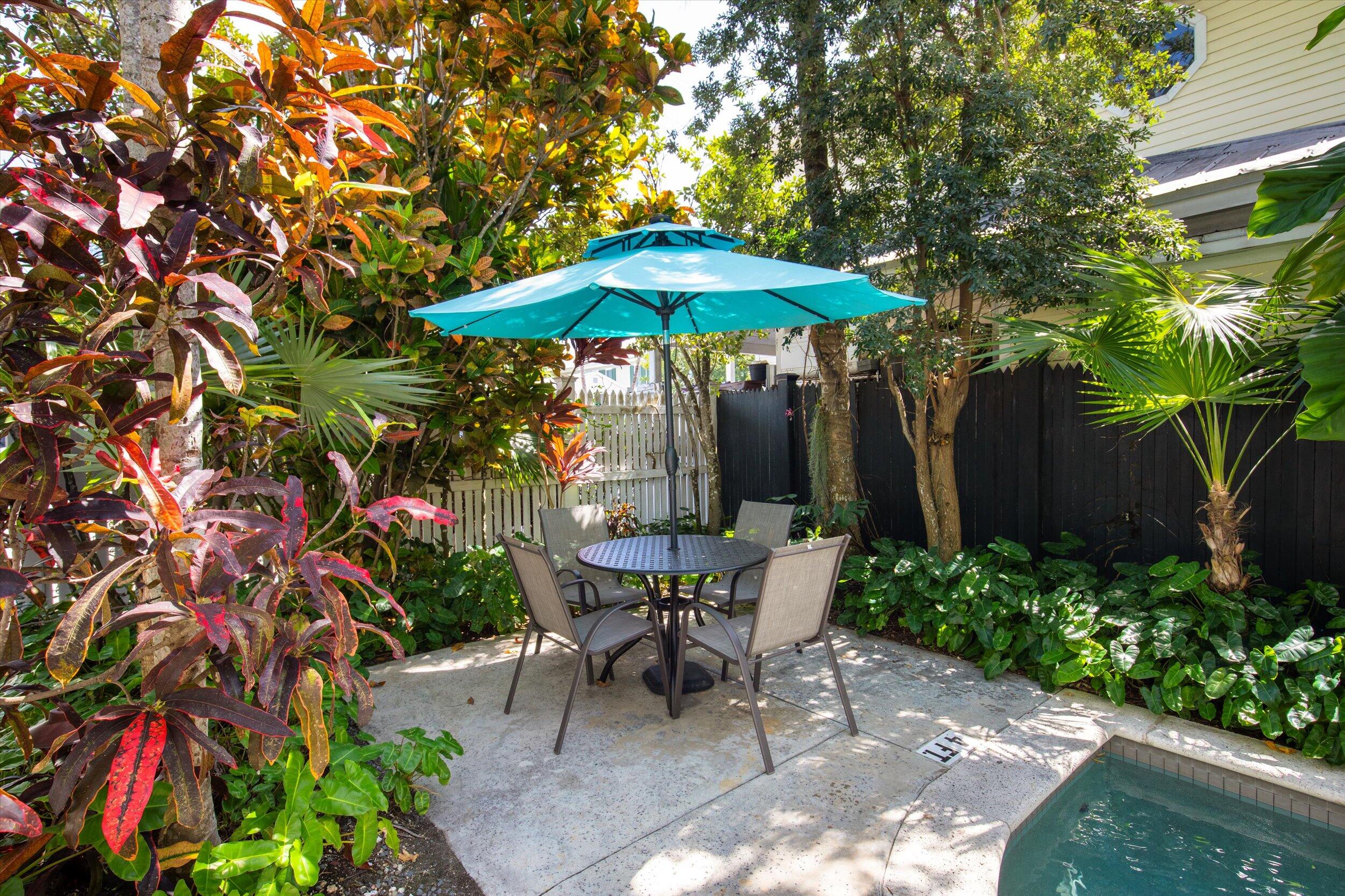 120 Angela Street, Unit 102 Key West, FL 33040 - Photo 18 of 24 a patio with a table and chairs under an umbrella
