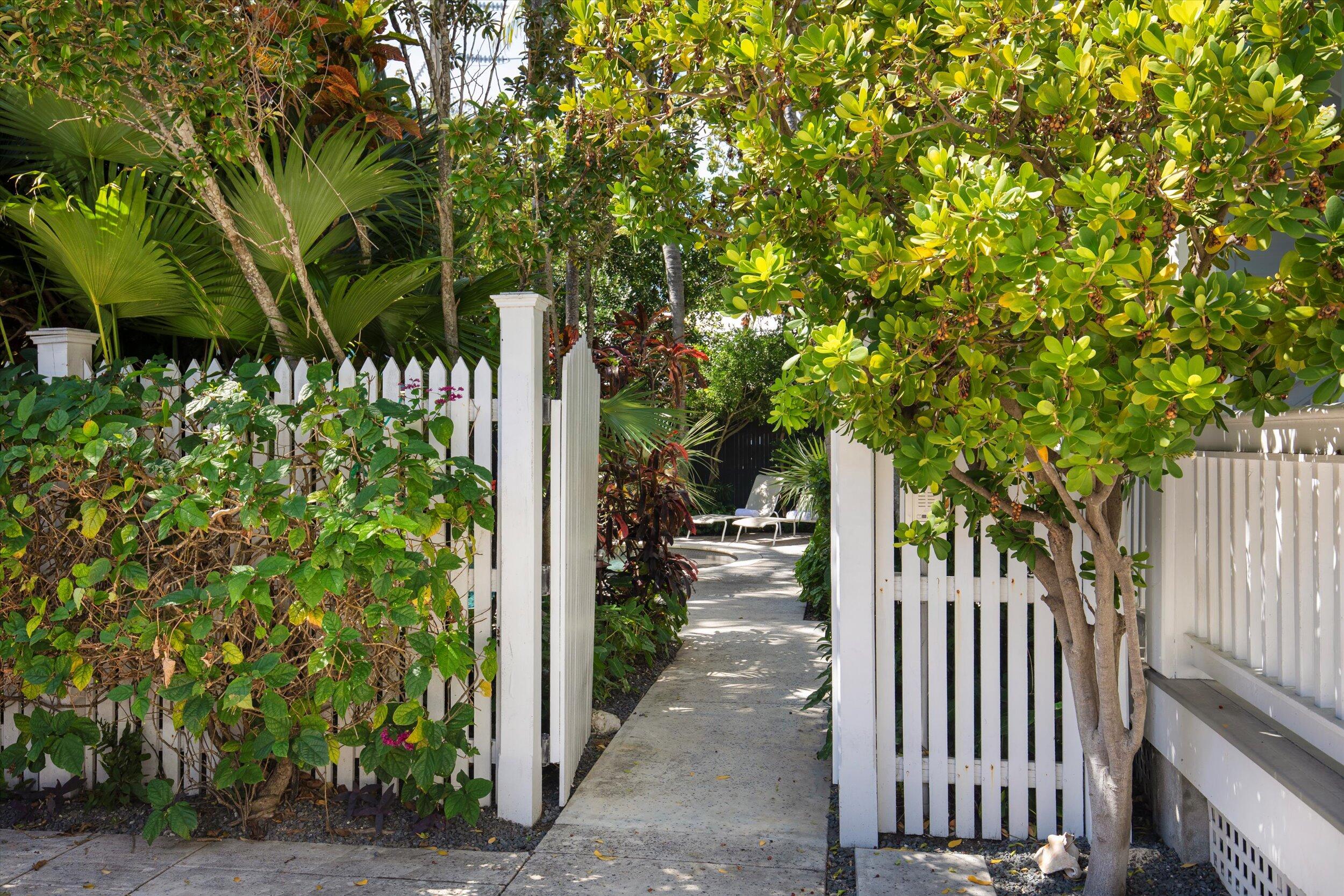 120 Angela Street, Unit 102 Key West, FL 33040 - Photo 19 of 24 a view of a pathway of a yard with plants and wooden fence