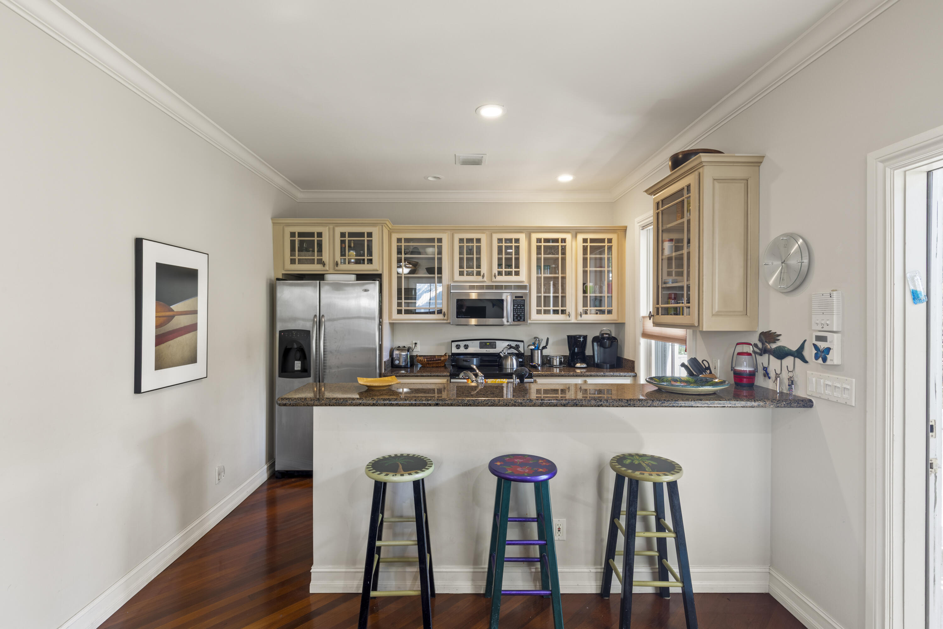 120 Angela Street, Unit 102 Key West, FL 33040 - Photo 4 of 24 a kitchen with stainless steel appliances granite countertop a dining table chairs and wooden floor