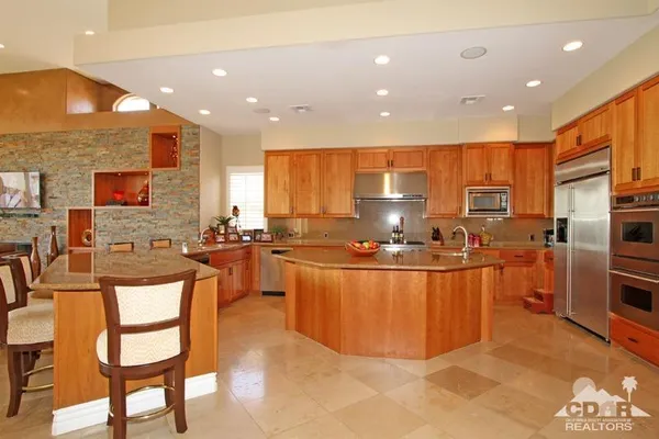 a kitchen with stainless steel appliances granite countertop a refrigerator a stove top oven a sink and dishwasher