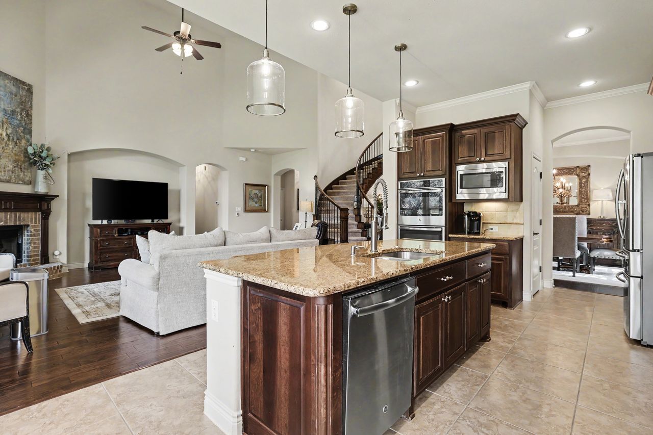 809 Prairie Dunes Drive Georgetown, TX 78628 - Photo 15 of 40 A well-appointed kitchen island with gleaming countertops and integrated appliances anchors this open-concept living space.