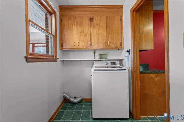 an empty room with a chandelier fan and windows
