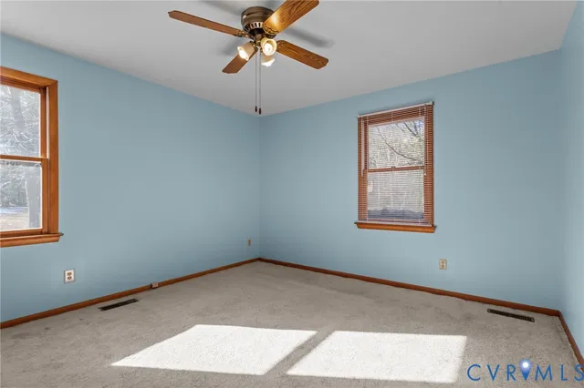 a view of swimming pool with outdoor seating and trees in the background