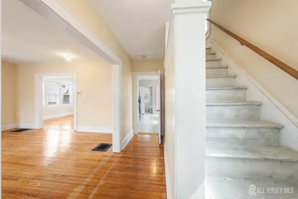 a view of an entryway with wooden floor and a living room
