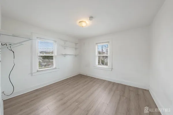 a view of a livingroom with wooden floor and windows