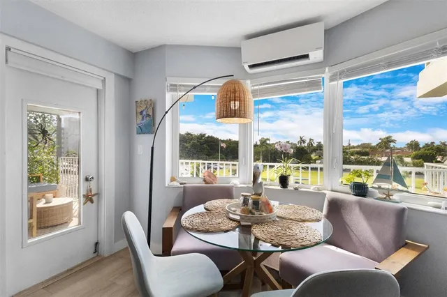 a dining room with furniture large windows and wooden floor