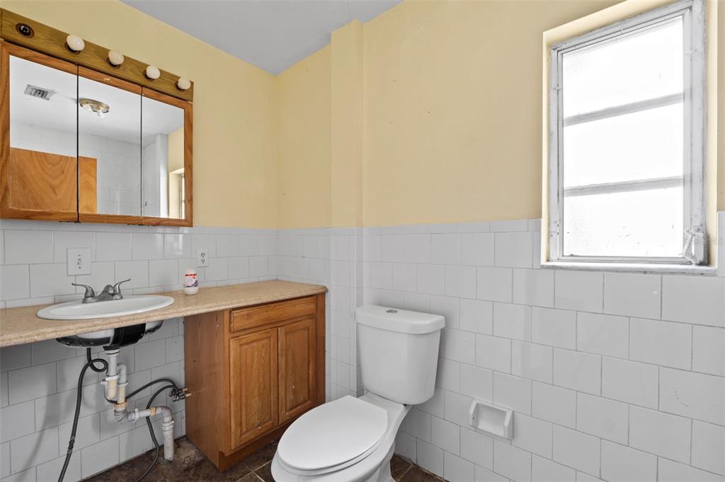 330 West 4th Street Frostproof, FL 33843 - Photo 17 of 39 a bathroom with a sink a toilet and mirror