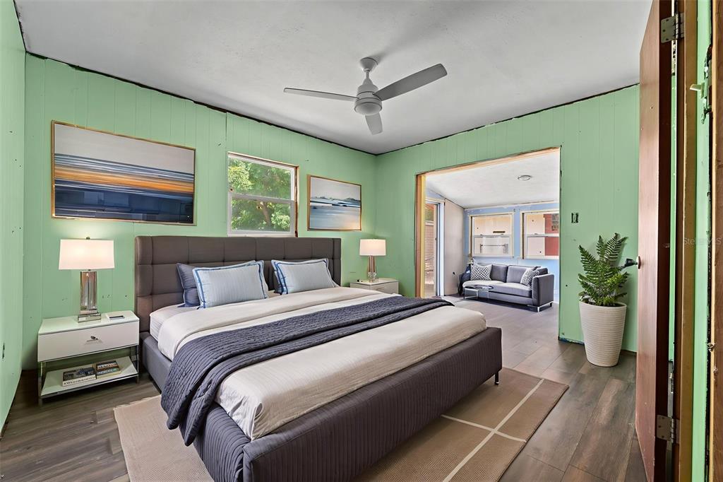 330 West 4th Street Frostproof, FL 33843 - Photo 21 of 39 a spacious bedroom with a large bed and a chandelier