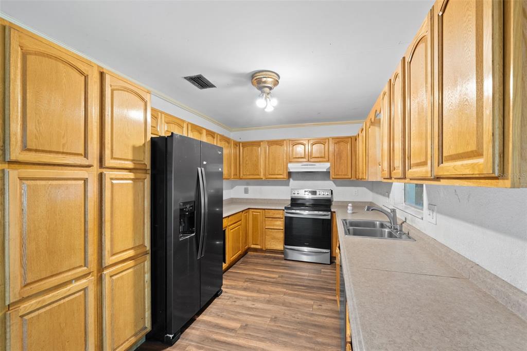 330 West 4th Street Frostproof, FL 33843 - Photo 9 of 39 a kitchen with stainless steel appliances granite countertop a refrigerator a stove a sink and a refrigerator