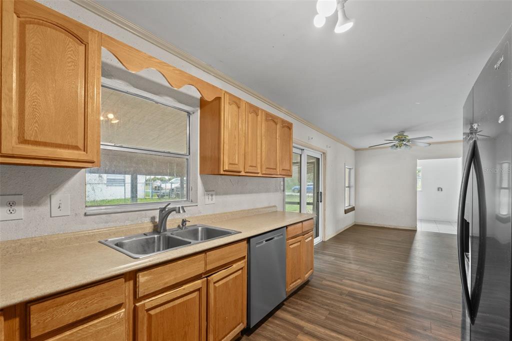 330 West 4th Street Frostproof, FL 33843 - Photo 10 of 39 a kitchen with a sink a refrigerator and cabinets