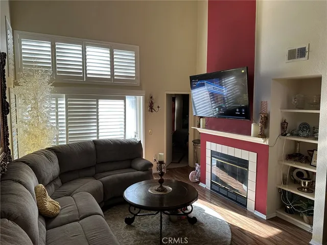 a living room with furniture a flat screen tv and a fireplace