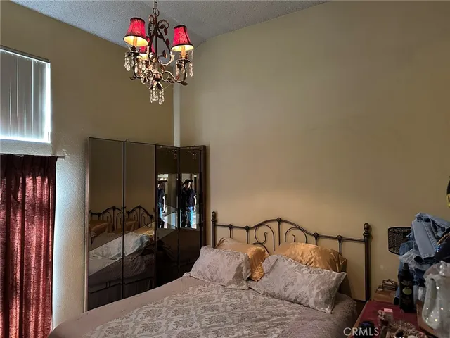 a bedroom with a bed and a chandelier