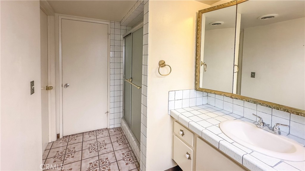 1702 East Bach Street Carson, CA 90745 - Photo 40 of 48 a bathroom with a granite countertop sink a mirror and a shower