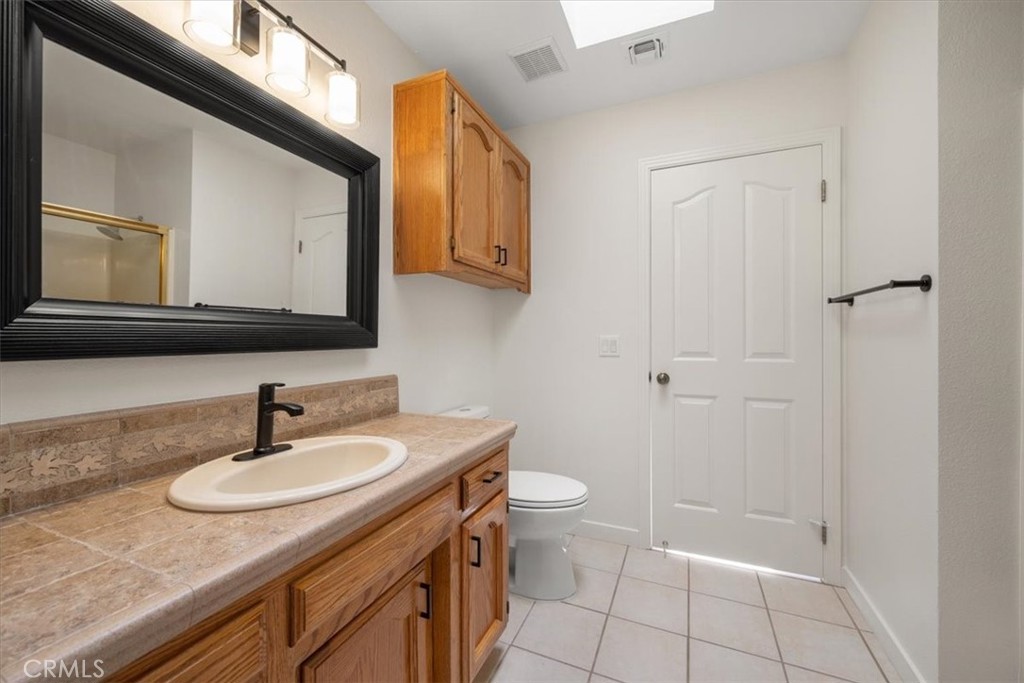 836 Casals Drive Paso Robles, CA 93446 - Photo 22 of 33 a bathroom with a sink a toilet a mirror and vanity
