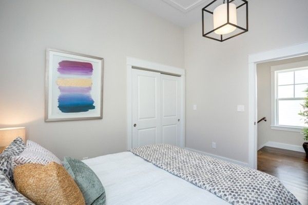 a bedroom with a bed and a painting on the wall