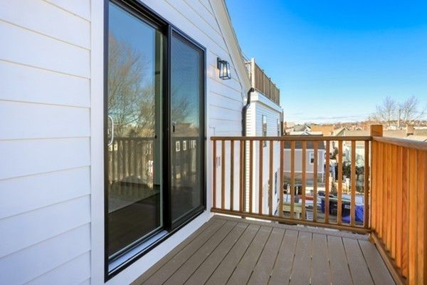a view of a balcony with wooden floor and floor to ceiling window