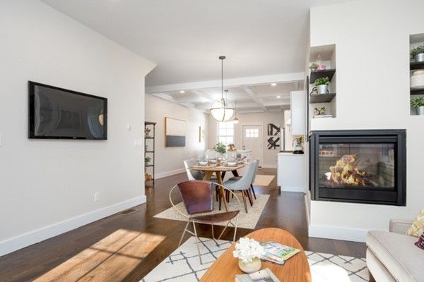 a living room with furniture a flat screen tv and kitchen view