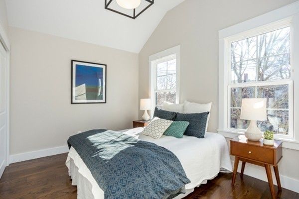 a bedroom with a bed and a table in it next to a window