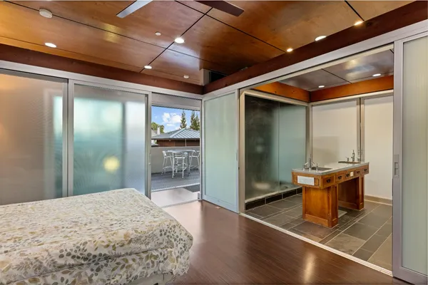 a spacious bedroom with a bed and wooden floor