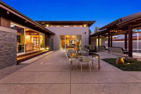 a view of a patio with a table and chairs under an umbrella