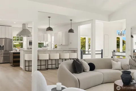 a living room with furniture white walls and large windows