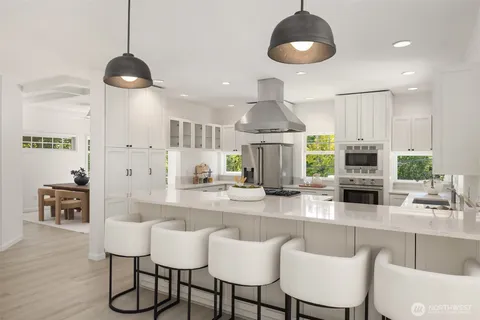 a kitchen with stainless steel appliances a dining table chairs and a chandelier