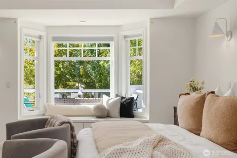 a bedroom with furniture and a large window