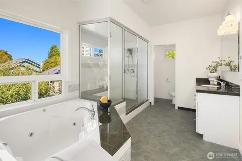 a bathroom with a tub a sink and a window