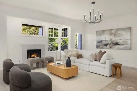 a living room with furniture a chandelier and a fireplace