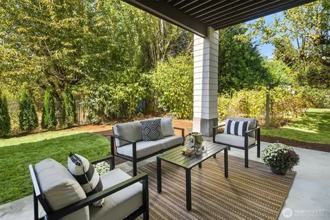 a view of chairs and table in patio with yard