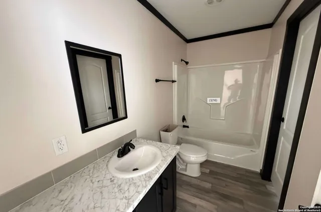 a bathroom with a granite countertop sink mirror vanity and toilet