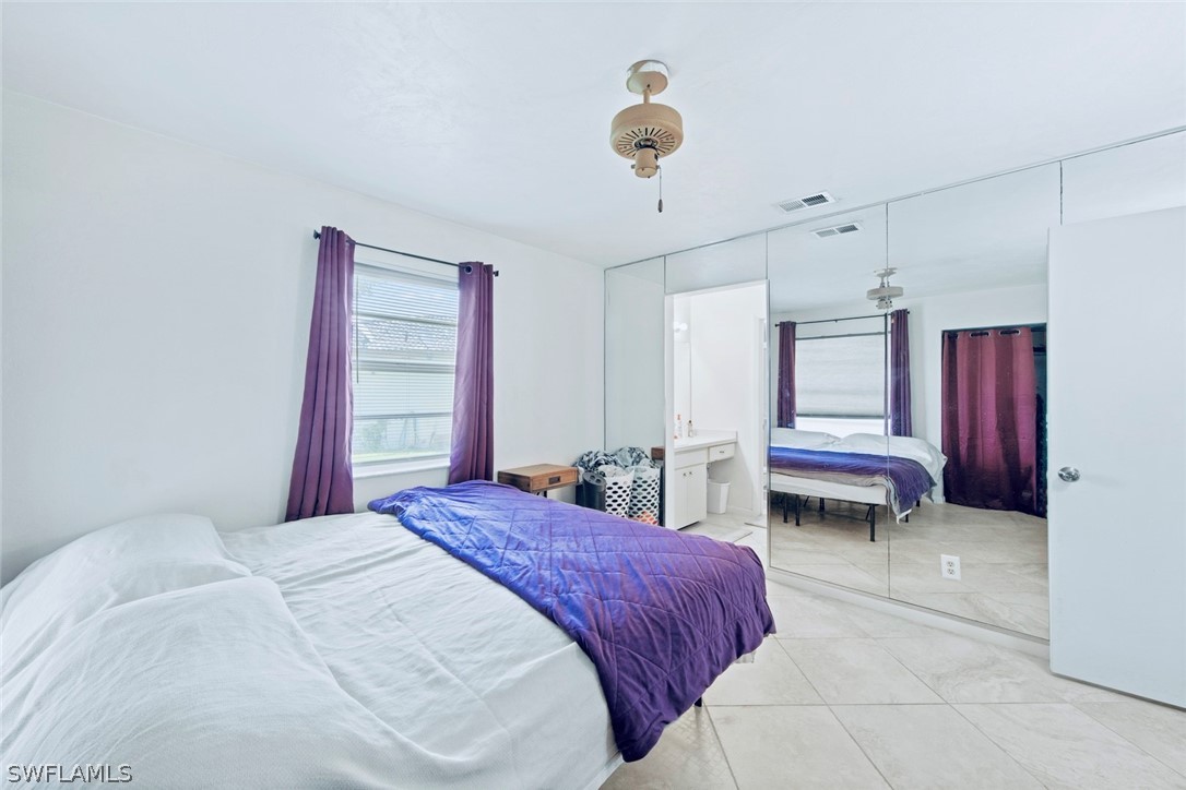 1604 Ridgecrest Street Lehigh Acres, FL 33936 - Photo 14 of 26 a bedroom with a bed and a chandelier
