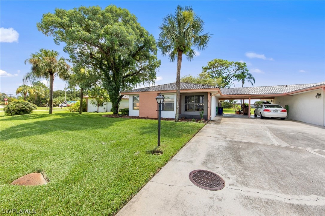 1604 Ridgecrest Street Lehigh Acres, FL 33936 - Photo 3 of 26 a view of a white house with a yard and potted plants
