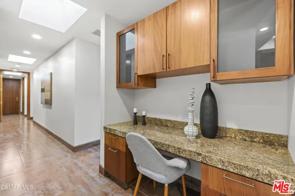 a kitchen with granite countertop a sink and white cabinets
