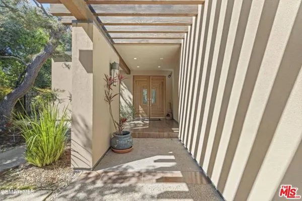 a view of a hallway with wooden floor and a potted plant