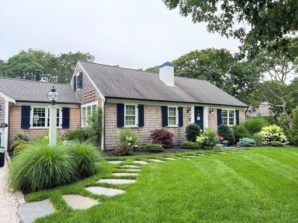 219 Training Field Road Chatham, MA 02633 - Photo 2 of 24 a front view of a house with a yard and potted plants
