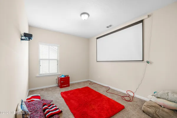 a bedroom with a bed and a flat tv screen on the dresser