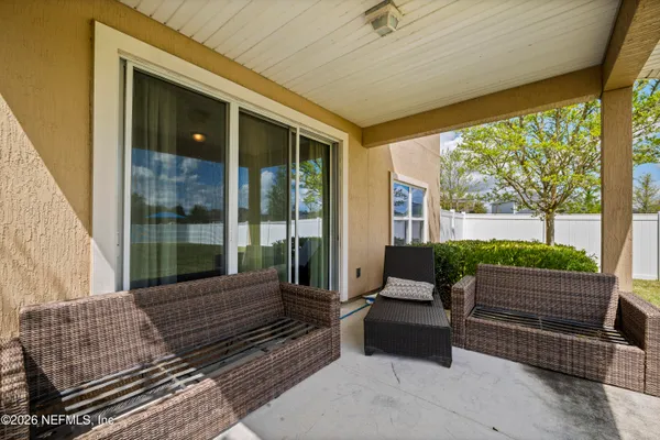 a view of a patio with couches and a table and chairs with wooden fence