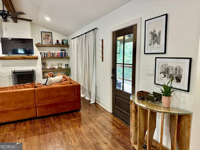 a bedroom with a bed wooden floor and a large window