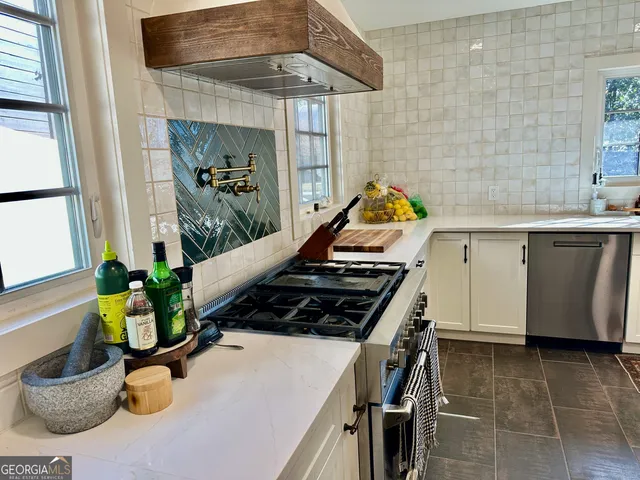 a kitchen with stainless steel appliances a stove a refrigerator and a sink with wooden floor