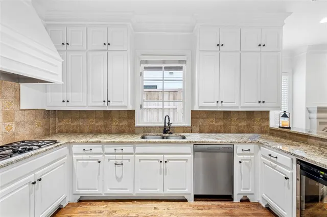 a white kitchen with granite countertop stainless steel appliances