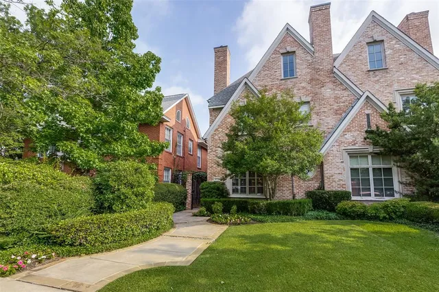 a front view of a house with a yard and trees