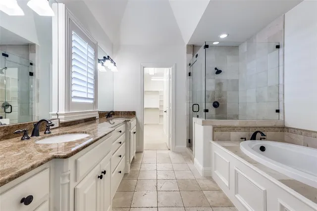 a spacious bathroom with a granite countertop tub sink shower and mirror