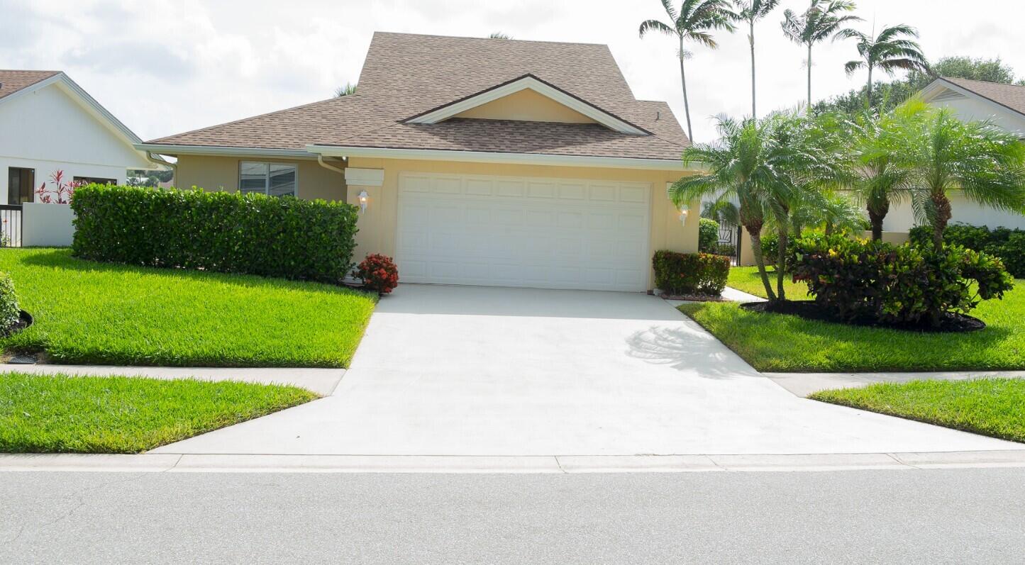 114 Beach Summit Court Jupiter, FL 33477 - Photo 2 of 32 a view of a house with a small yard and plants