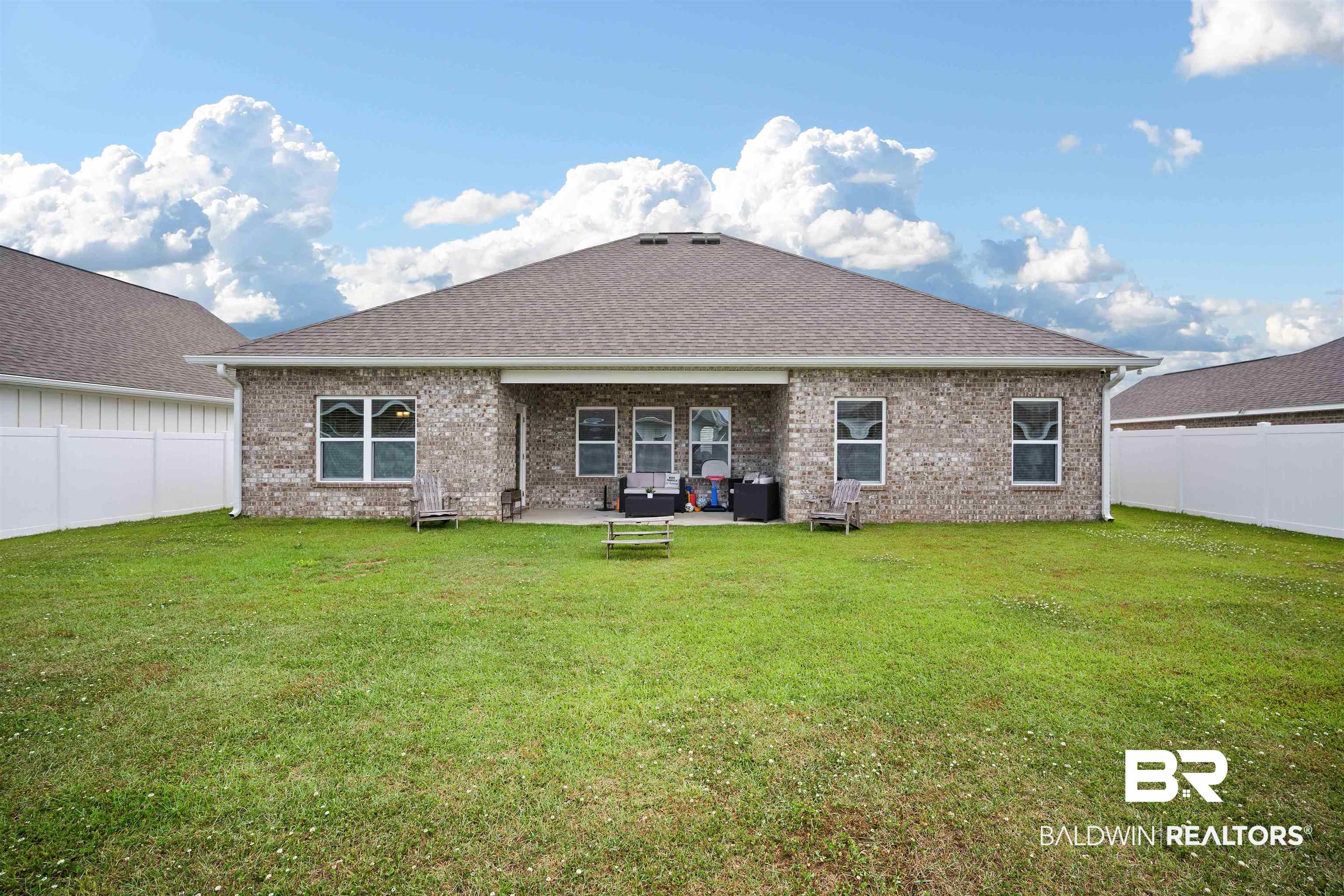 11021 Native Dancer Way Daphne, AL 36526 - Photo 25 of 35 Back of house with a fenced backyard, brick siding, and a lawn
