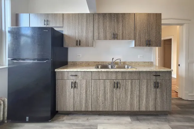 a kitchen with a refrigerator and cabinets